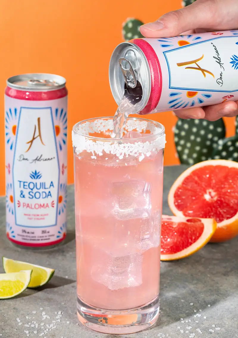 Versement d’une Paloma pétillante depuis la canette Don Adriano dans un verre au bord salé.